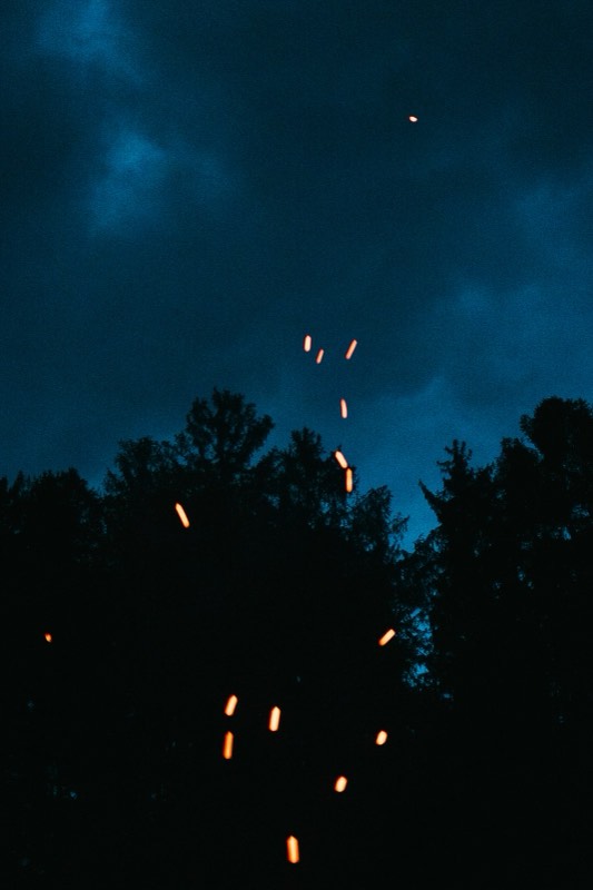 Funken steigen vom Lagerfeuer in den Nachthimmel