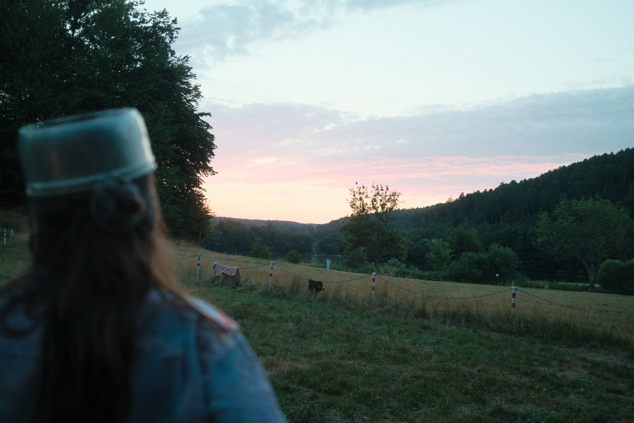 Person blickt bei Sonnenuntergang in die Ferne